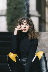 Trendy woman smoking on street