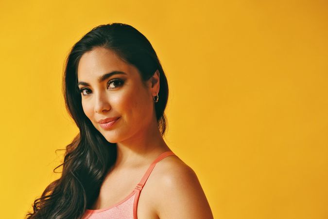 Side view headshot of Hispanic woman in yellow room