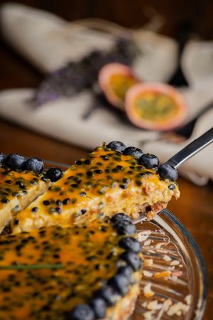 Tasty piece of passion fruit pie decorated with blueberry
