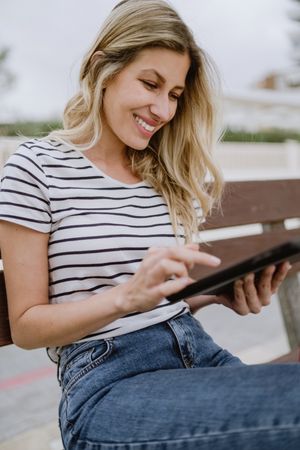 Woman sitting on bench and using tablet