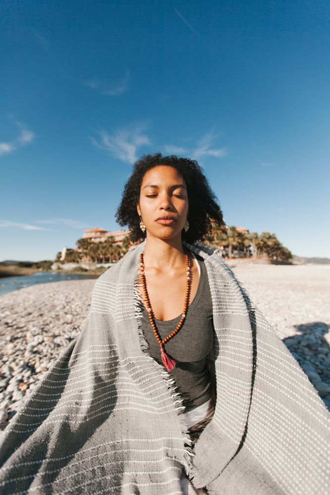Sportive woman sitting on sandy beach in asana