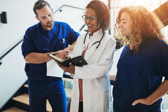 Group of doctors and nurses workers looking over a chart