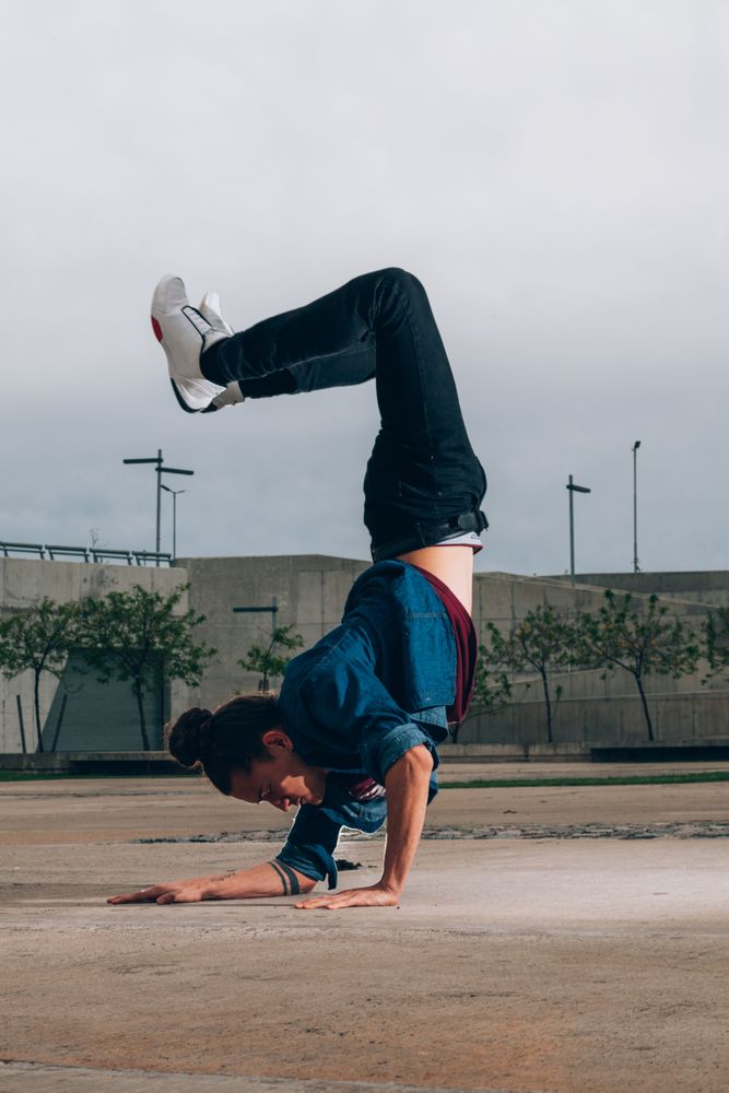 Skillful break dancer performing handstand while moving