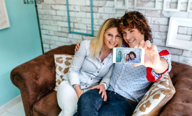 Top view of couple taking selfie on a sofa