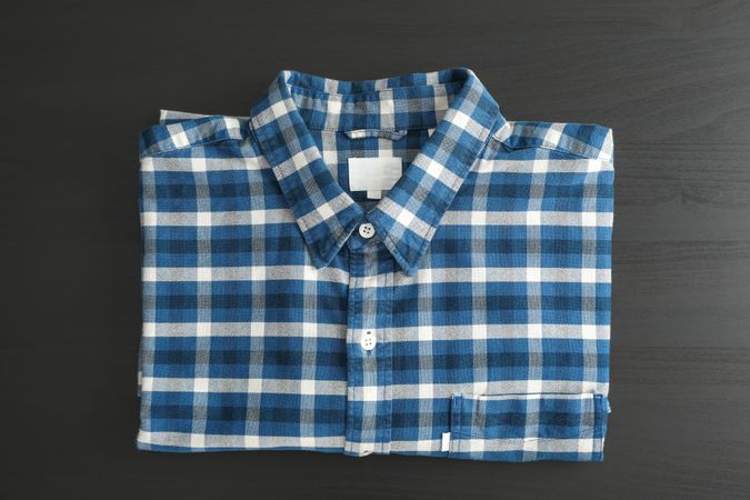Folded checkered shirt on table, top view