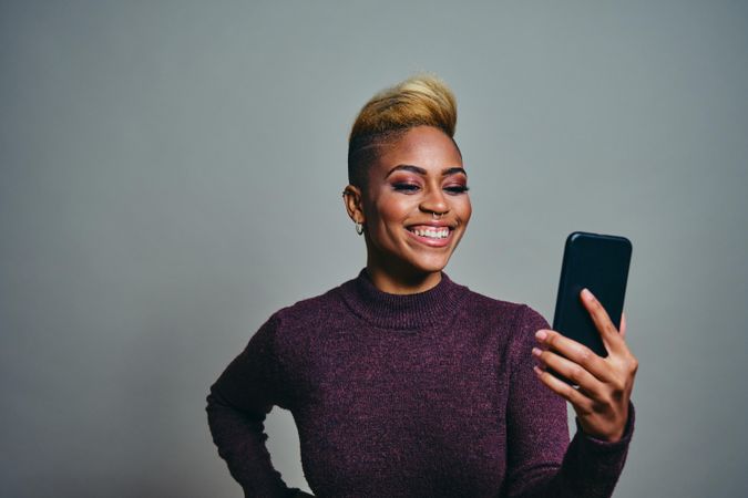 Black woman smiling at a text on a cell phone