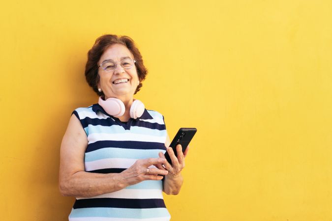 Smiling older woman using smartphone outdoors