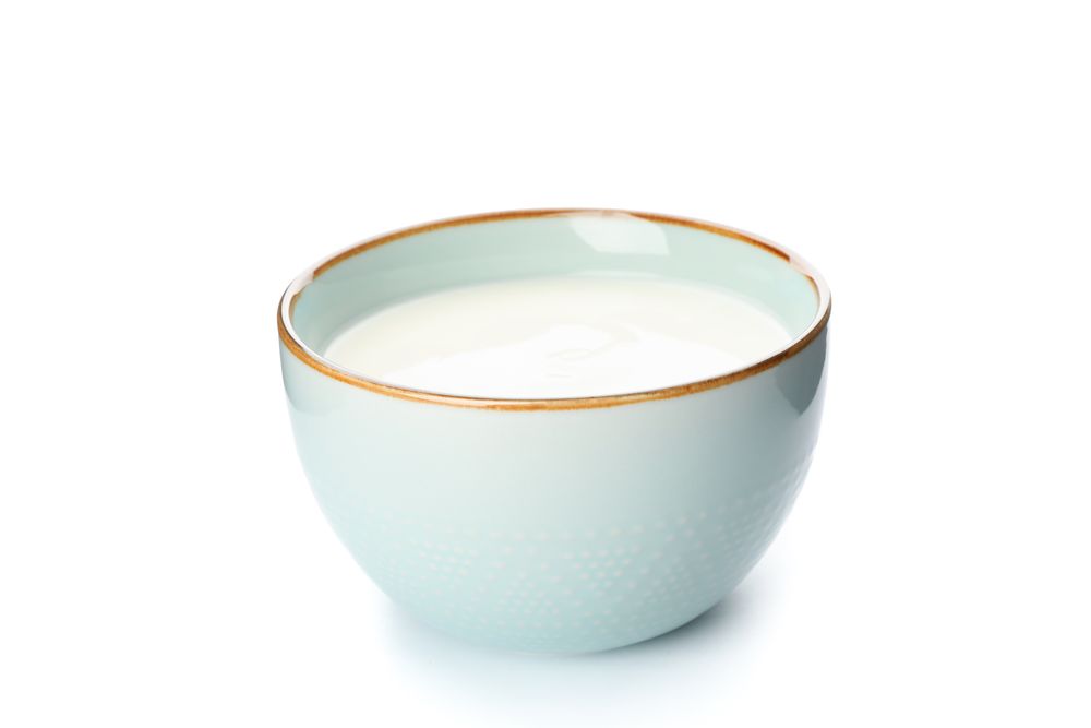 Bowl of sour cream yogurt isolated on plain background