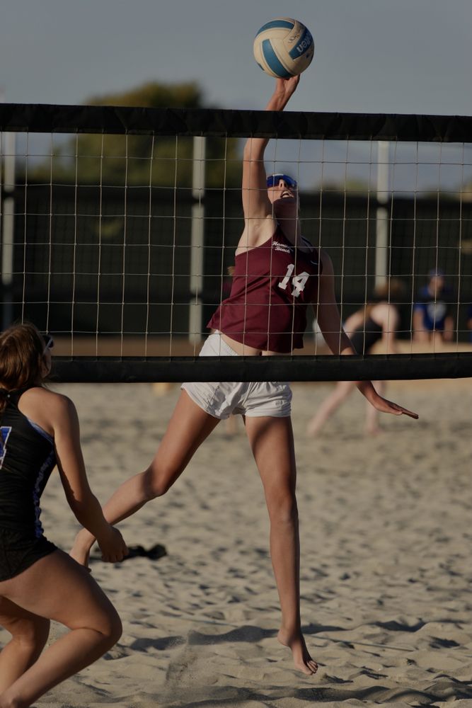 Two women playing volleyball at the beach