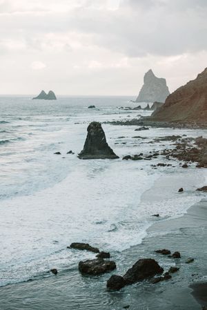 Lonely cliff in sea on cloudy day