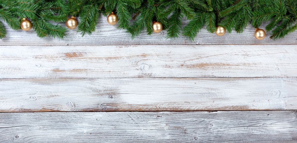 Christmas evergreen branches and golden ornaments on vintage wooden planks