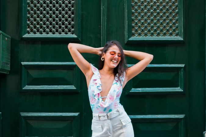 Confident stylish woman in sunglasses standing on city street