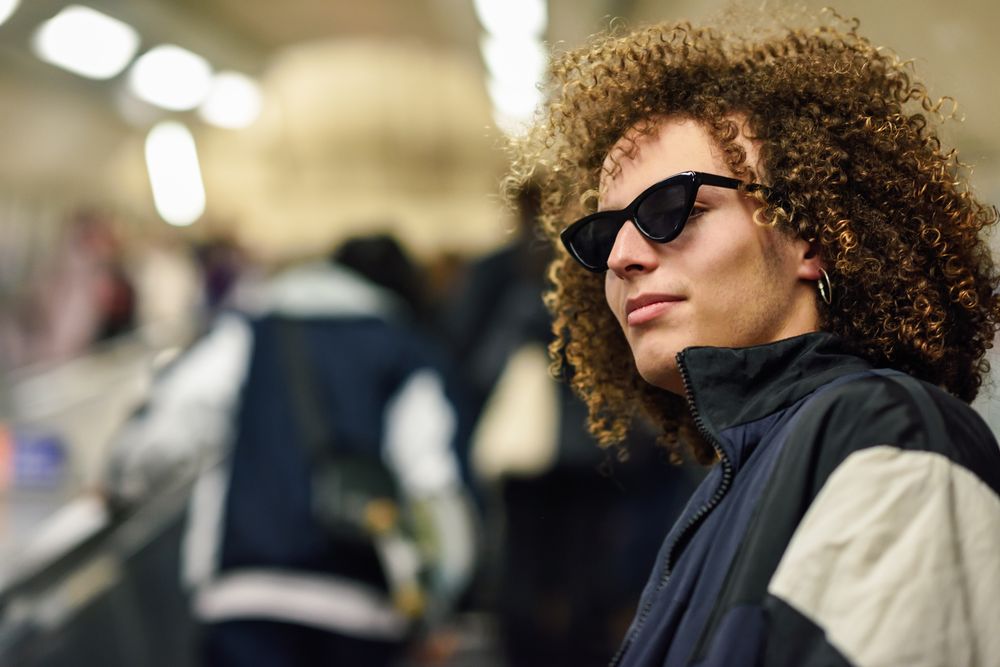 Man looking around with sunglasses in an underground station in London