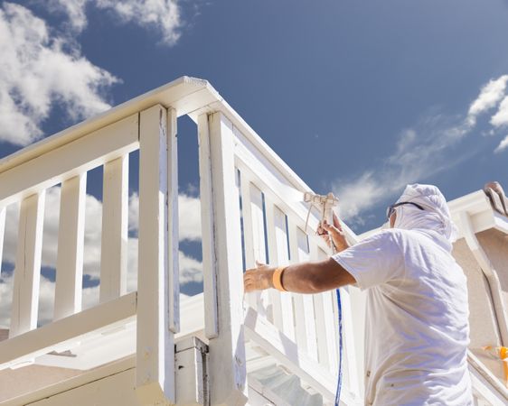 House Painter Spray Painting A Deck of A Home