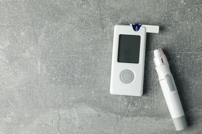 Blood glucose meter on gray background, space for text