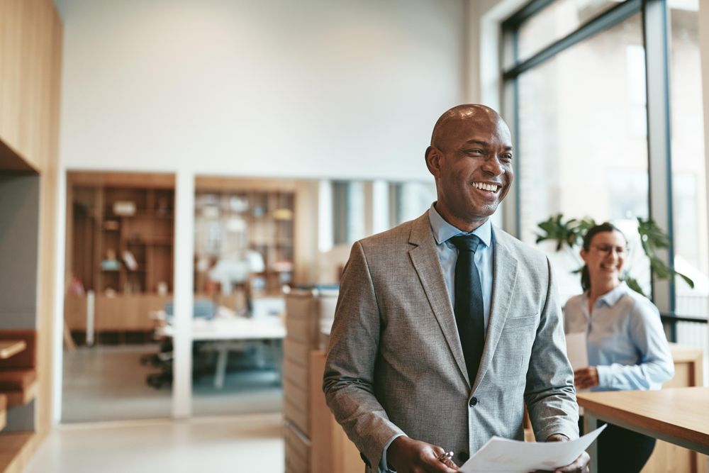 Smiling man in suit standing in a modern bright office