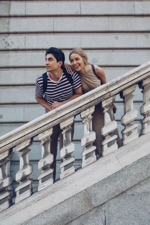 Young couple standing on ancient stairs against wall