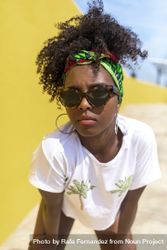Serious Black woman with sunglasses and headband leaning towards camera 5pgkeg