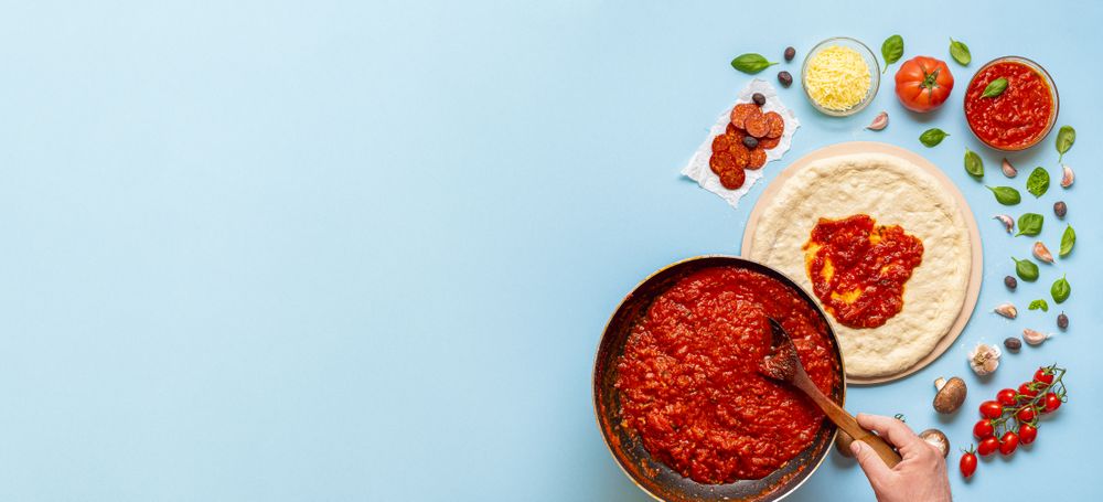 Large bowl of tomato sauce and pizza dough