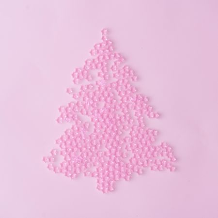 Christmas tree made of pink star decoration on pastel pink background