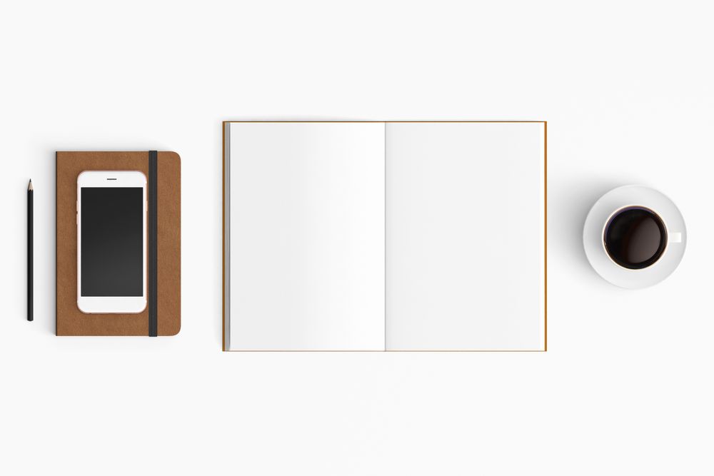 Modern workspace with coffee cup, smartphone, paper, notebook