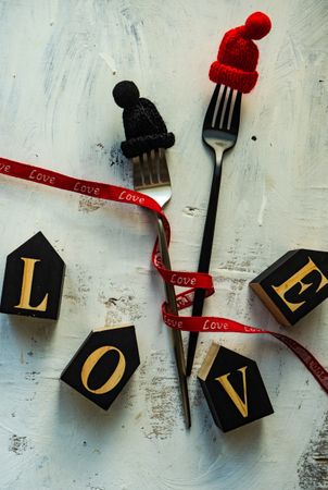 Love spelled in blocks on table with cutlery