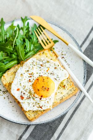 Delicious breakfast of fried eggs with toast and salad.