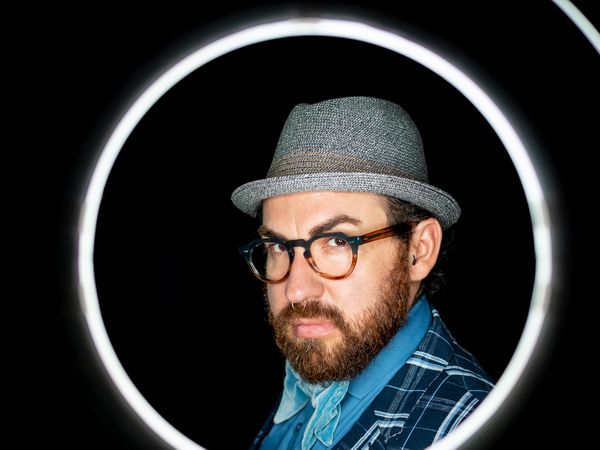 Stylish man in elegant suit behind special circle light