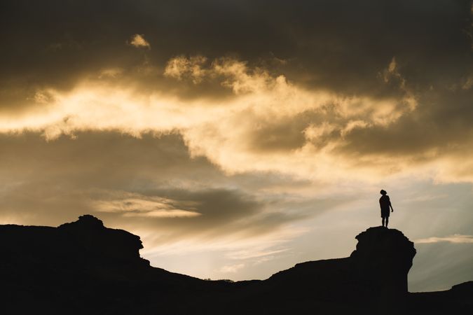 Man on mountain under beautiful sky