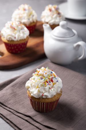 Tasty party cupcakes on the table. Cupcakes with whipped cream.