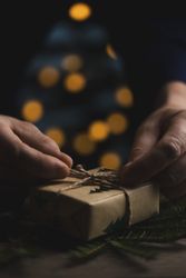 Man tying jute bow on Christmas gift