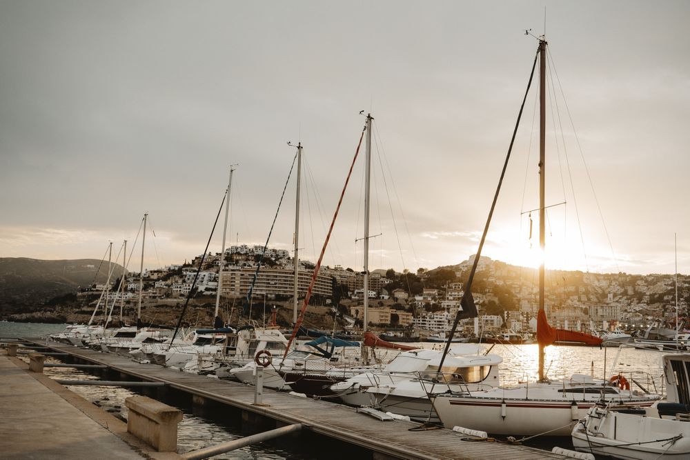 Yachts docked in sea port at sunset