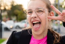 Girl giving peace sign and yelling in excitement.
