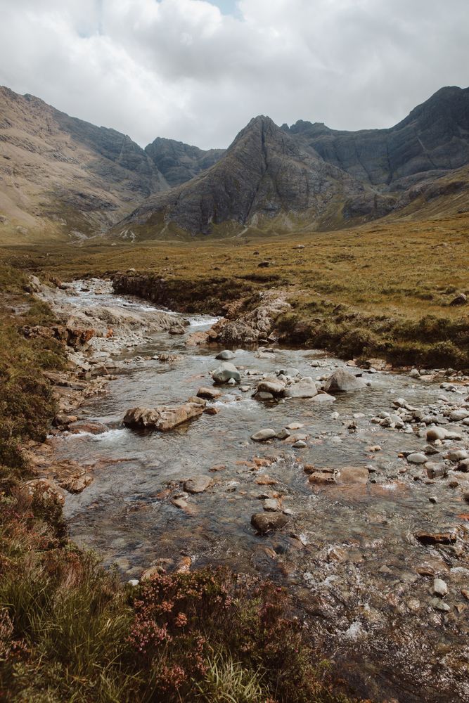 Picturesque view of stream by high mountains