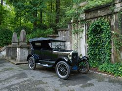 Antique Model T Ford parked by gray stone mansion DbGlx0