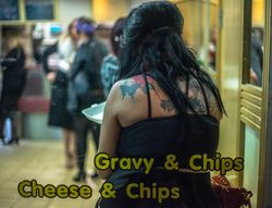 Back of adult woman in tank top with back tattoos sitting in restaurant behind window sign