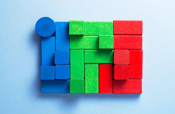 Blue, green and red wooden blocks over blue background