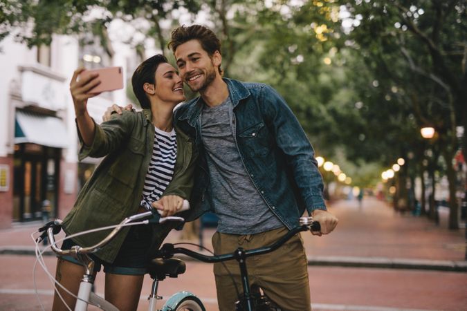Romantic couple with bicycles taking selfie