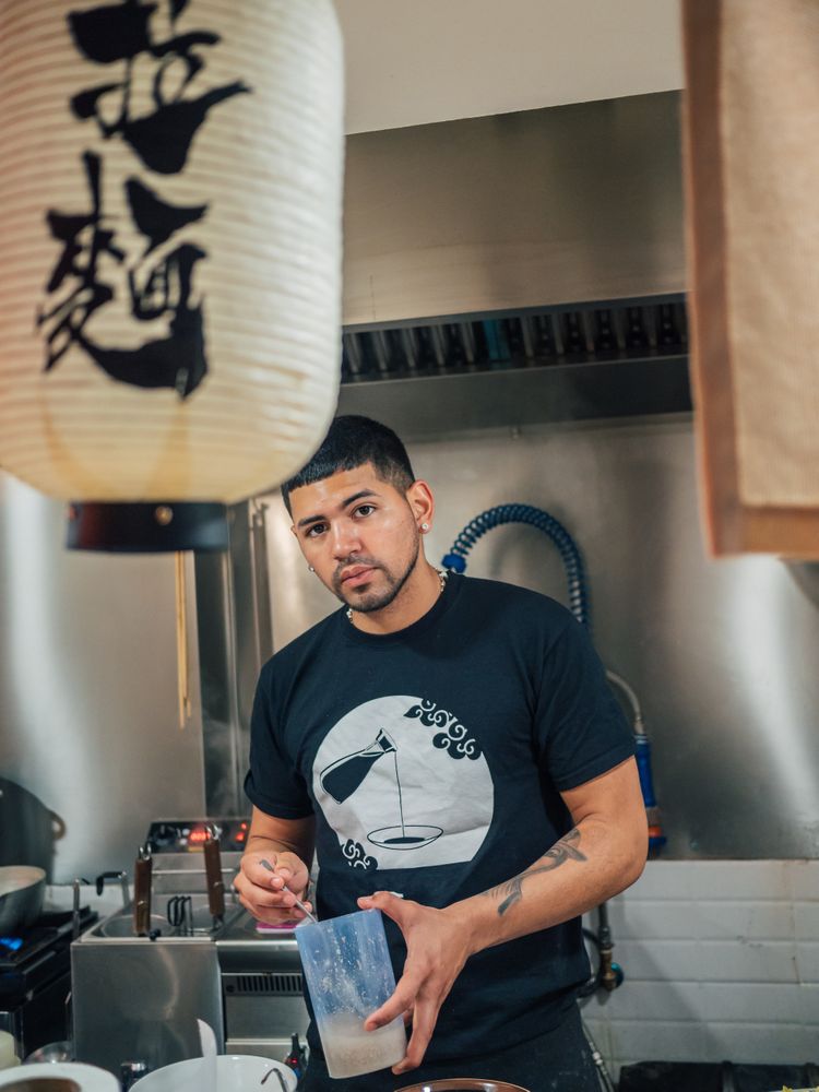Handsome male stirring sauce in kitchen