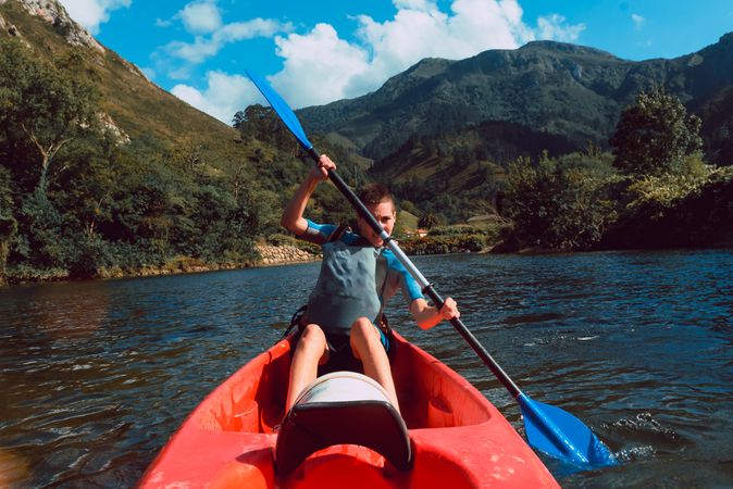 Young female kayaking on nature background
