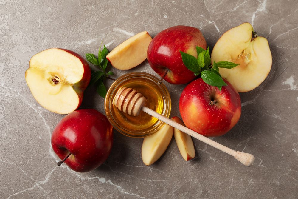 Top view of apples and honey on marble