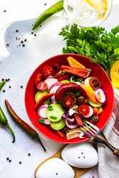 Top view of colorful healthy raw vegetable salad served in red bowl