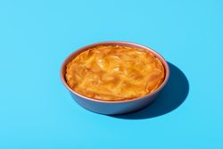 Balkan phyllo spinach cake isolated on a blue background
