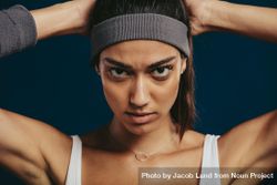 Close-up of a confident sportswoman with a headband staring at camera 4OLKgb