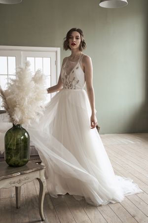 Young woman with red lips in elegant white dress looking at camera