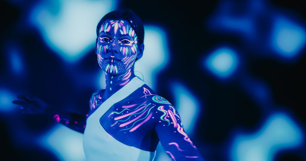 Creative Young Female Covered in Neon Body Paint Performing Modern Dance Choreography in a Studio