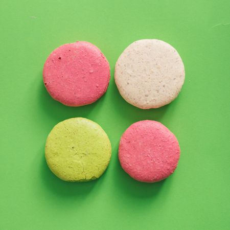 Colorful French macaron on bright green background