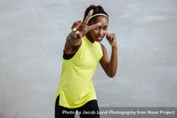 Sporty woman stretching arm out with peace sign gesture 56VDY5