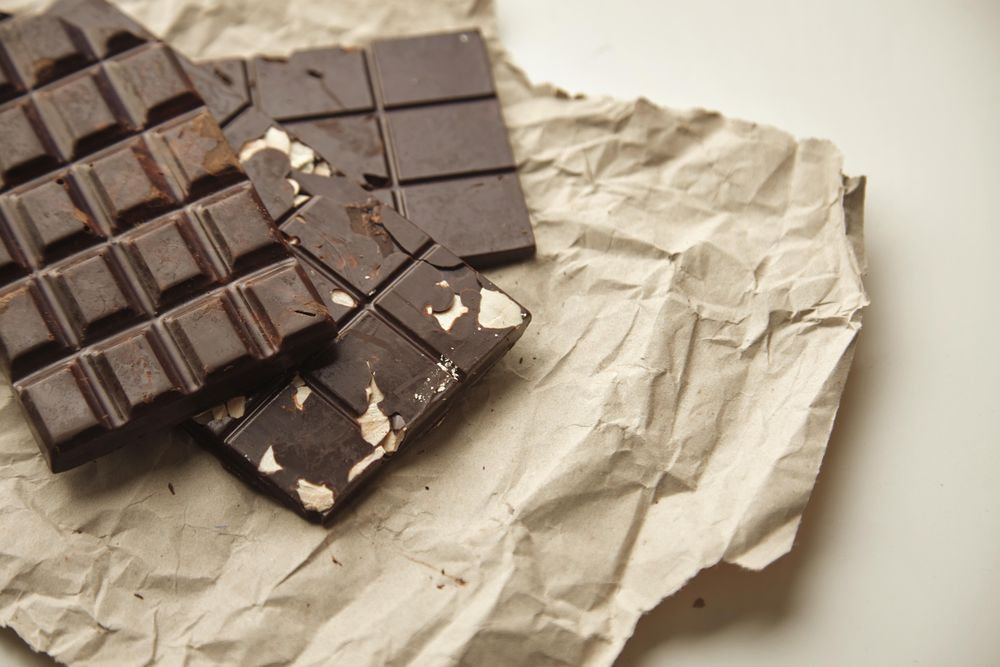 Top view of stack of three chocolate bars on paper