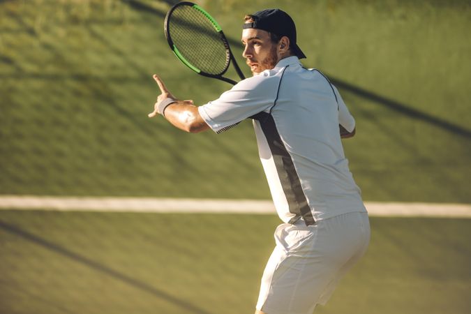 Tennis player playing a match on club hard court